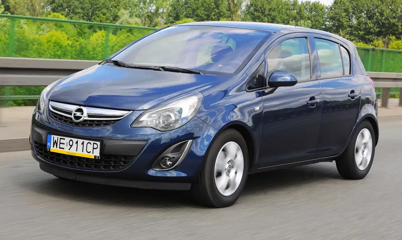 Granatowy Opel Corsa D 1.2 benzyna w ruchu drogowym.