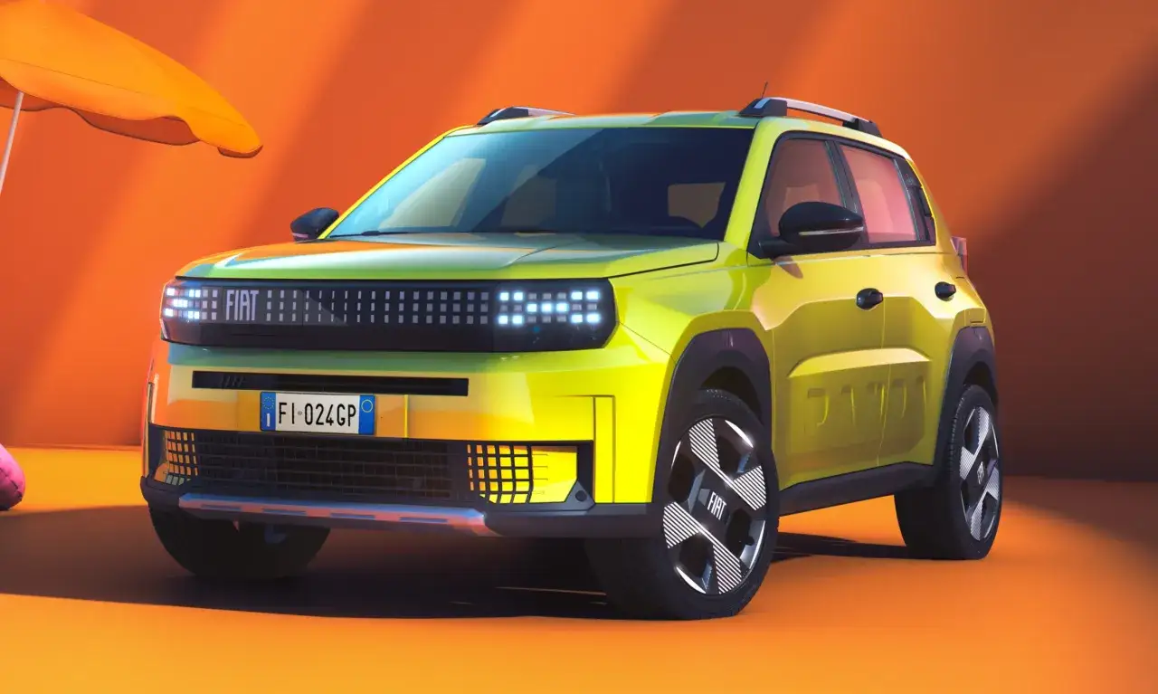 Jaskrawożółty fiat elektryczny z nowoczesnymi światłami i felgami, gotowy na letnią przygodę pod pomarańczowym parasolem.