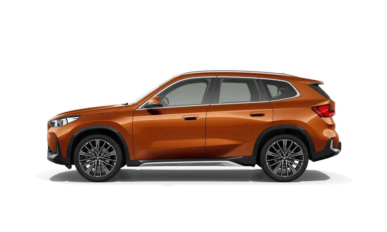 Pomarańczowy BMW X1 w profilu. Zwróć uwagę na jego dynamiczną sylwetkę i nowoczesne felgi, które podkreślają jego wymiary.