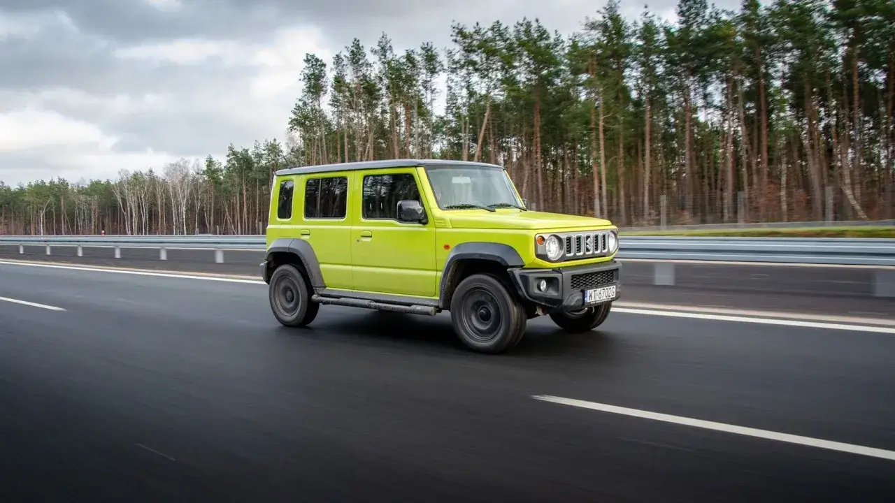 Jaskrawozielony Suzuki Jimny 5-drzwiowy na drodze. Sprawdź suzuki jimny 5-drzwiowy cena i możliwości tego terenowego auta.