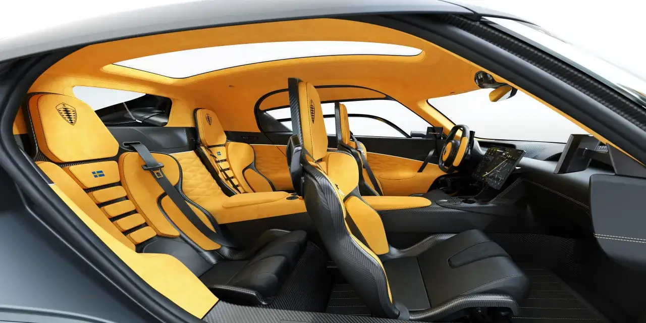 Wnętrze Koenigsegg Gemera: żółta alcantara, sportowe fotele z włókna węglowego i panoramiczny dach.