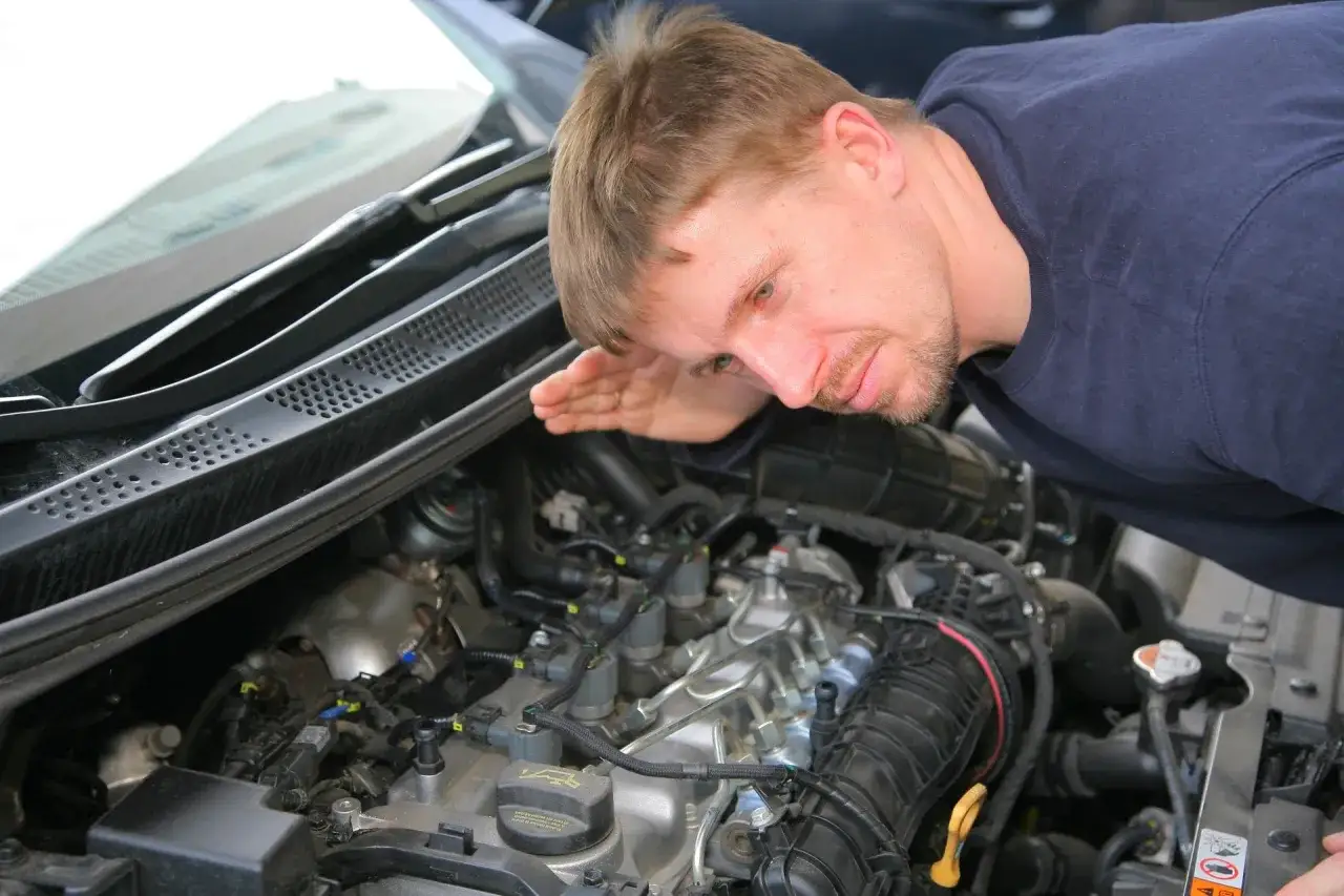 Mechanik nasłuchuje silnika, szukając objawów uszkodzonej odmy.