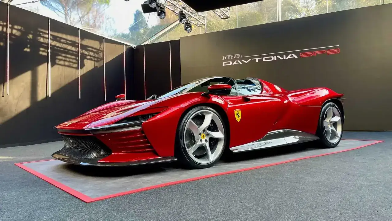 Czerwony Ferrari Daytona SP3 prezentuje swoje aerodynamiczne linie na tle czarnej ściany z logo.
