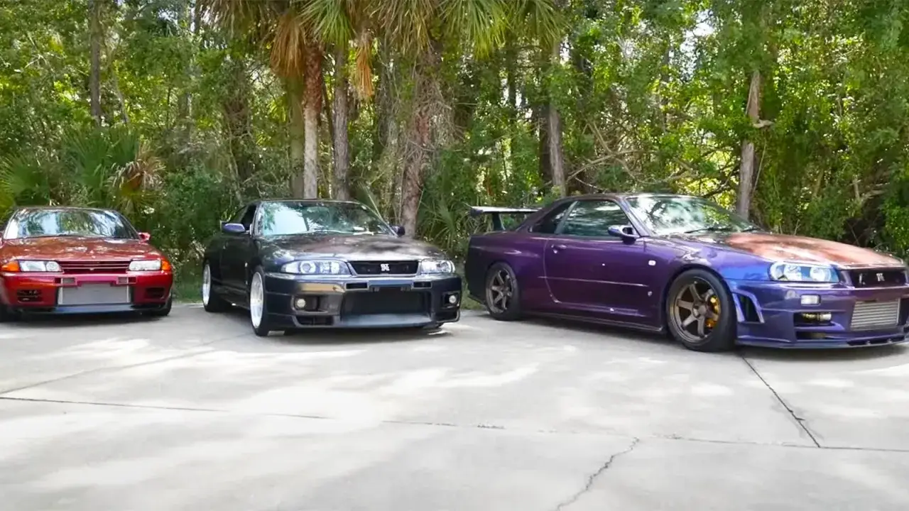 Trzy kultowe Nissan Skyline: czerwony r32, czarny r33 i fioletowy r34 stoją obok siebie.