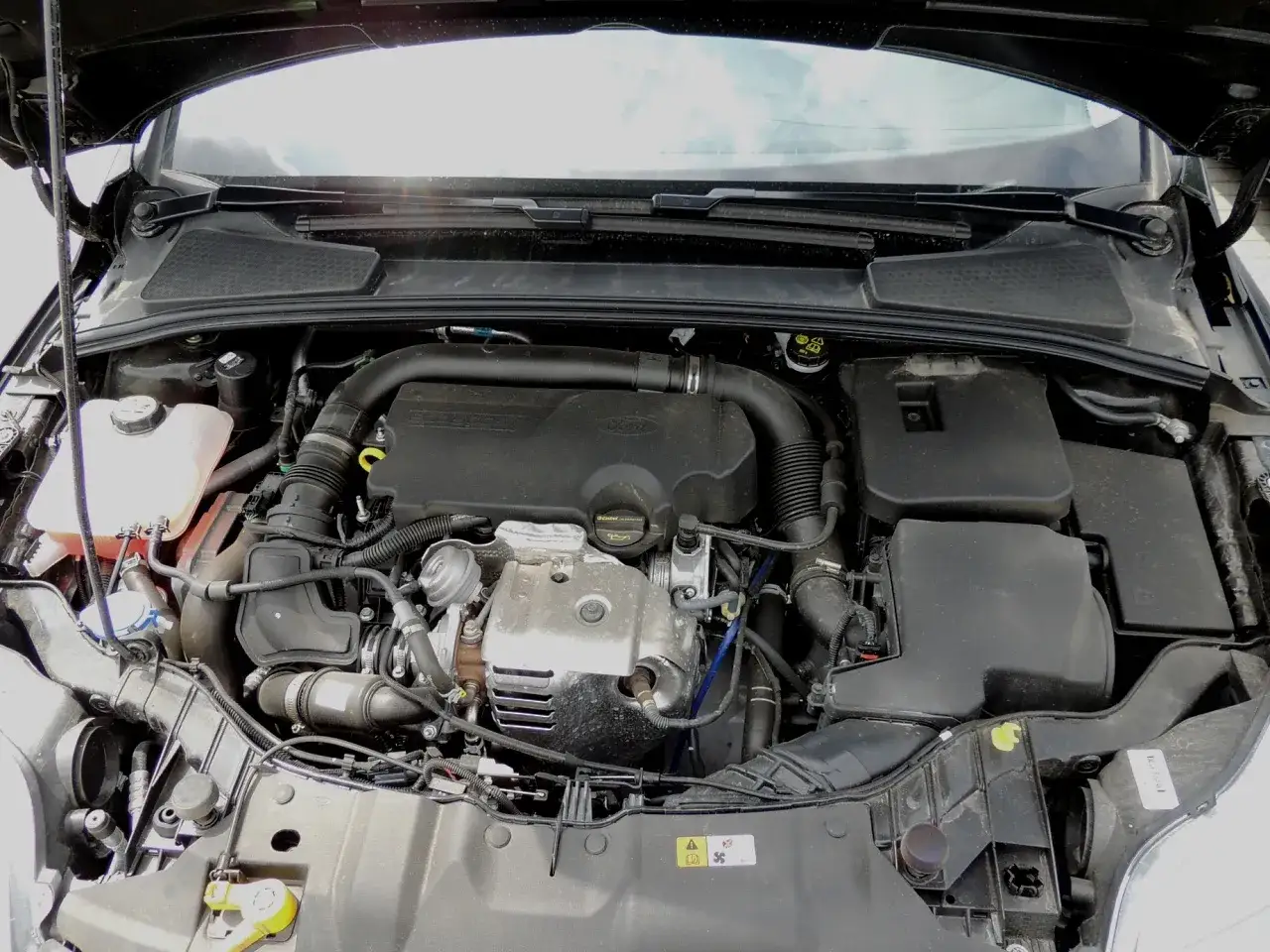 Silnik EcoBoost w samochodzie, widok z góry. Widać turbosprężarkę i inne elementy.