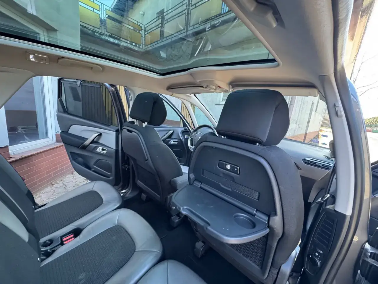 Wnętrze Citroen C4 Spacetourer z panoramicznym dachem i rozkładanymi stolikami.
