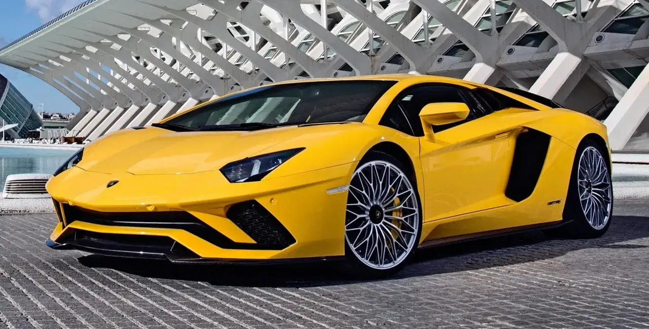 Żółty Lamborghini Aventador zaparkowany przed nowoczesną architekturą.