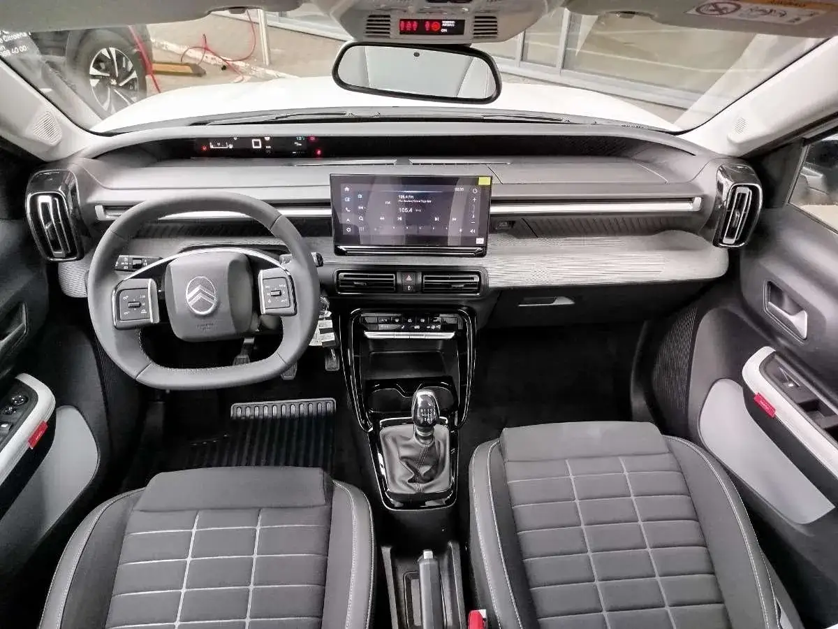 Wnętrze nowoczesnego c3 citroen z ekranem dotykowym, kierownicą i wygodnymi fotelami.