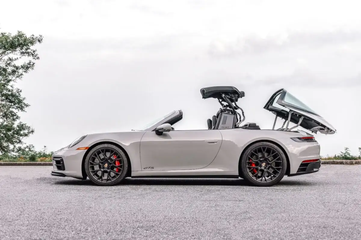 Szary Porsche 911 Targa GTS z otwartym dachem, gotowy na przejażdżkę.