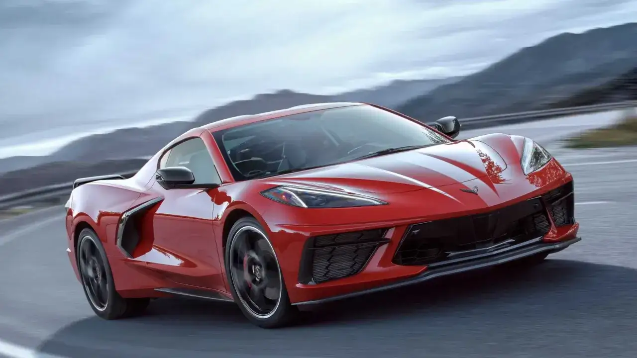Czerwony Chevrolet Corvette C8 pędzi po krętej drodze. Sprawdź aktualną corvette c8 cena i marzenia o tym aucie mogą stać się rzeczywistością.