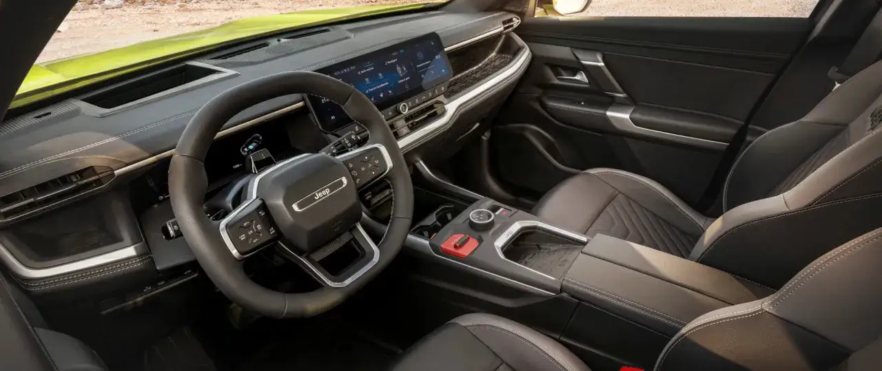 Wnętrze Jeep Compass 2025: nowoczesny kokpit z dużym ekranem, skórzana kierownica i komfortowe fotele.