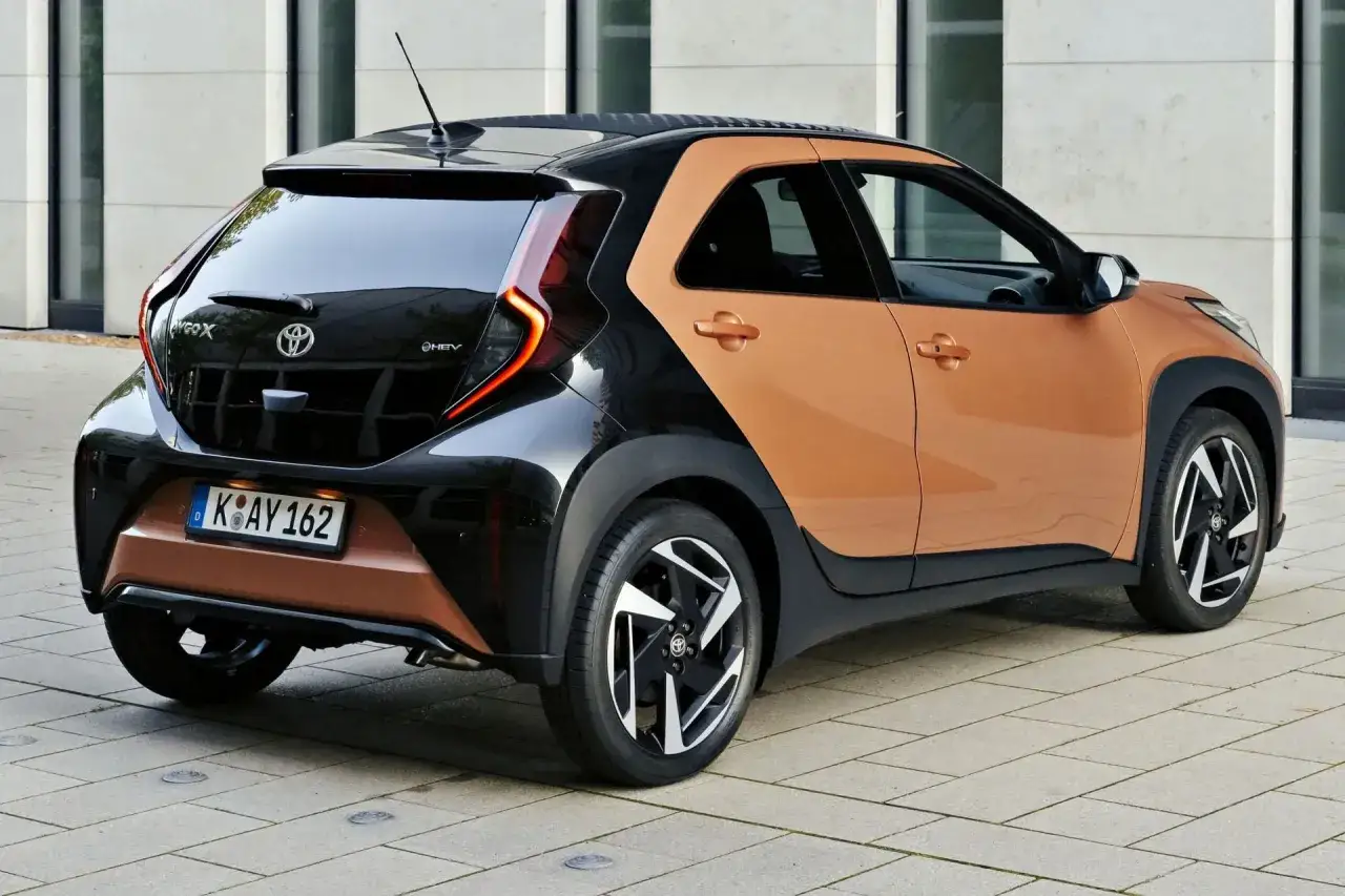Dwukolorowy Toyota Aygo X, z czarnym dachem i pomarańczowym nadwoziem. Sprawdź atrakcyjną toyota aygo x cena.