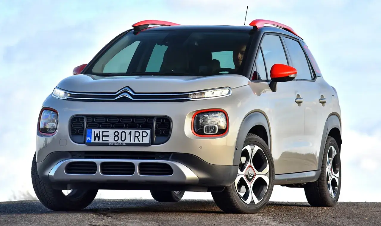 Beżowy mały SUV z czerwonymi akcentami, gotowy na miejskie przygody.