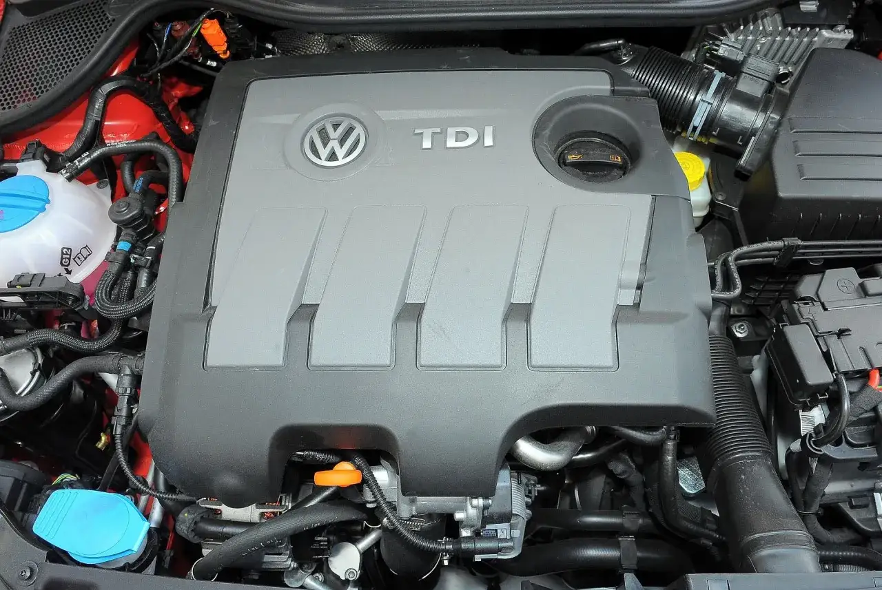 Silnik TDI w Volkswagen Polo 6R. Widoczny jest szary plastikowy dekiel z logo VW i napisem TDI, a także elementy układu chłodzenia i dolotowego.