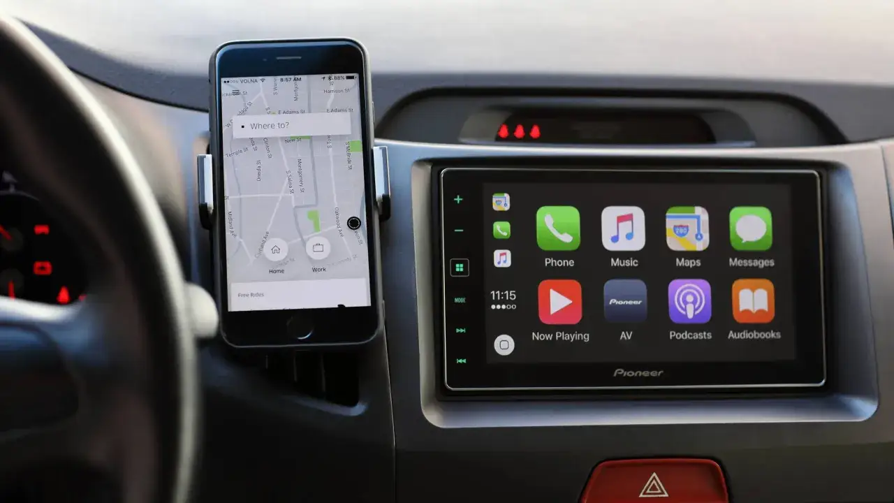 Smartfon z nawigacją Uber zamontowany na desce rozdzielczej, obok ekranu systemu multimedialnego Pioneer z funkcją mirror link.