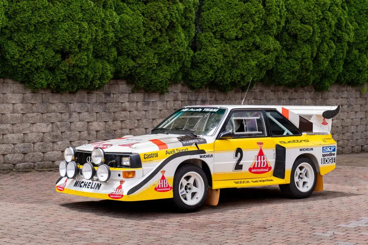 Biało-żółty Audi Sport Quattro z numerem 2, gotowy do rajdu, z logotypami Michelin i HB International.