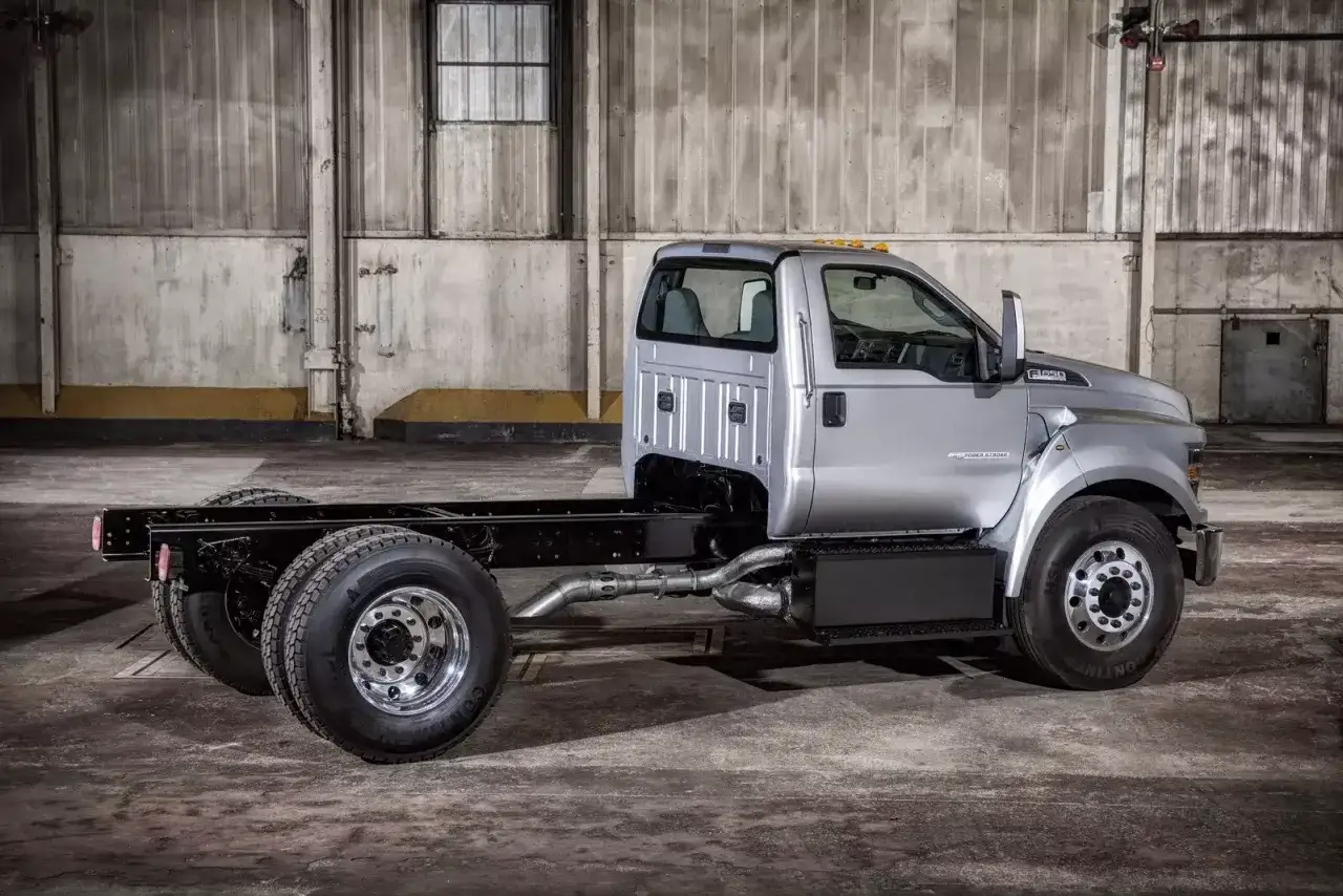 Srebrny Ford F650 bez zabudowy, gotowy do pracy w magazynie.