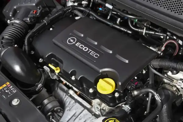 Silnik Ecotec w Oplu Astra J 1.4 Turbo. Widoczne elementy układu dolotowego i osłona silnika z logo.