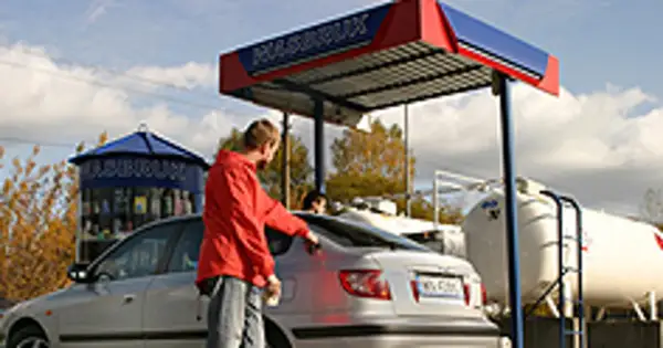Mężczyzna tankuje samochód na stacji LPG. Ekologiczne rozwiązania lpg to przyszłość motoryzacji.