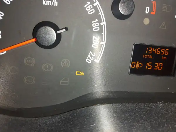 Kontrolki w Oplu: ABS, hamulec, poduszka, drzwi, bagażnik. Na wyświetlaczu przebieg 134696 km i czas 15:30.