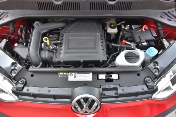 Silnik 1.0 TSI w czerwonym samochodzie Volkswagen. Widoczny akumulator, płyny i elementy układu dolotowego.