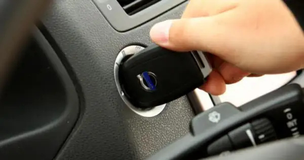 Dłoń wkłada kluczyk do stacyjki. To pokazuje, jak działa immobilizer, zabezpieczając auto przed kradzieżą.