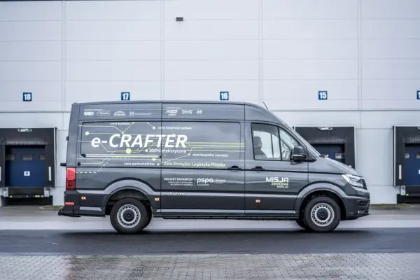 Szary e-Crafter z napisem "Misja Zerowa Emisja" pokazuje, ile kosztuje przerobienie samochodu na elektryczny, oferując zero kosztów paliwa i serwisu.