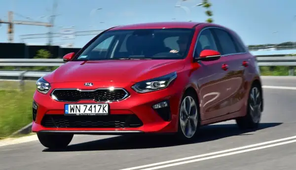 Czerwony Kia Ceed 1.4 benzyna w ruchu drogowym. Elegancki hatchback z dynamicznym wyglądem.