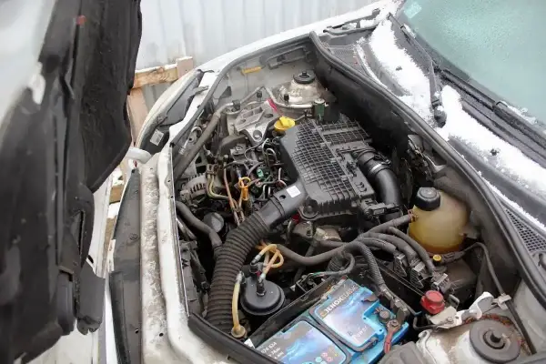 Silnik Renault Kangoo 1.5 dCi, widok komory silnika z otwartą maską. Widać akumulator, filtry i przewody.